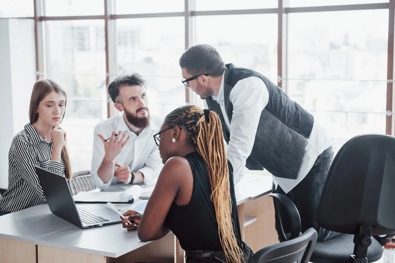 Группа занятых людей разных национальностей, работающих в офисе.